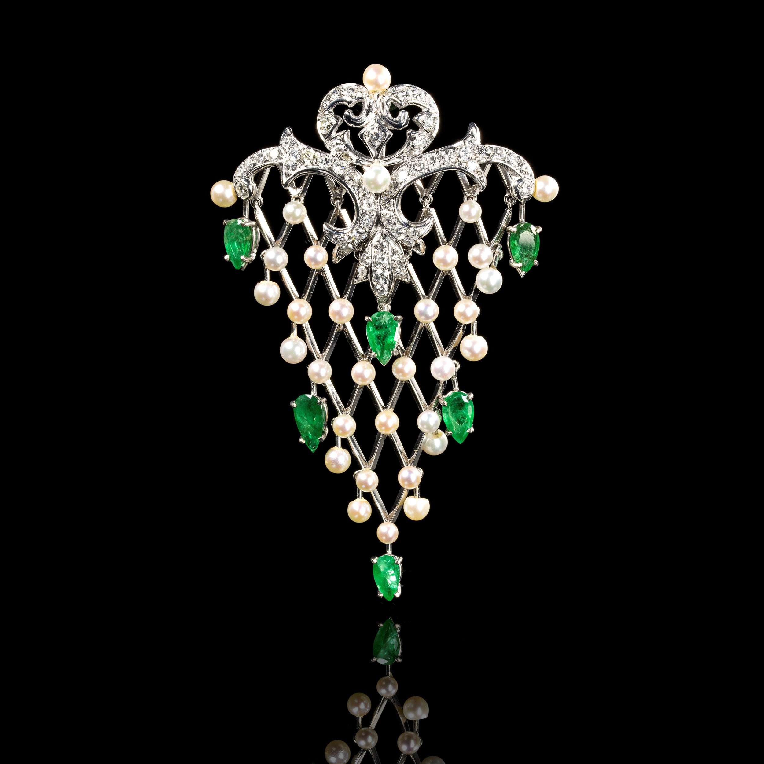 A gold emerald diamonds and pearl fishnet pendant.